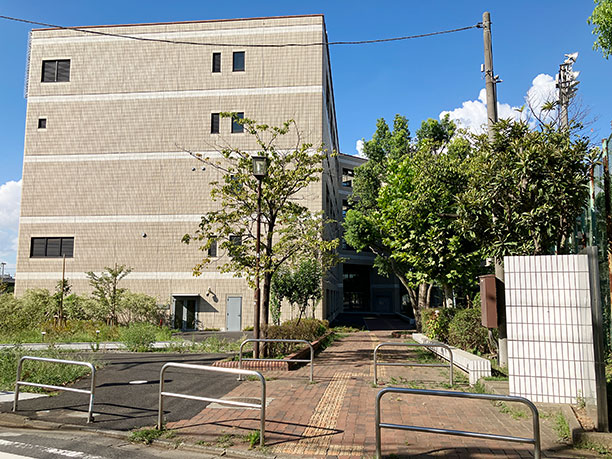 右手に見えてくるベージュの５階建ての建物が千葉大学墨田サテライトキャンパスです
