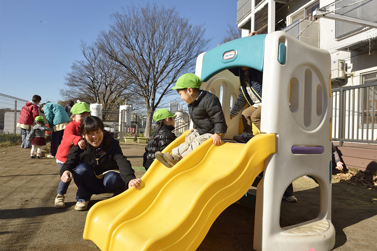 写真：保育園の滑り台で遊ぶ子供たち