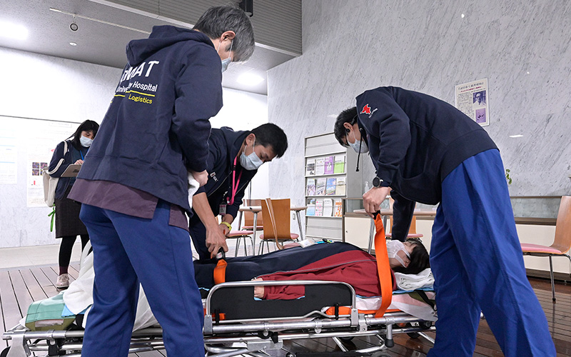 写真:傷病者に声をかけながら、慎重にストレッチャーへ移乗