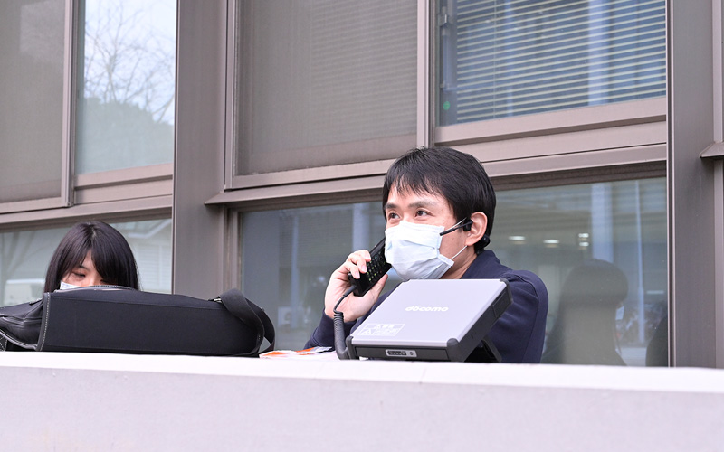 写真:衛星電話を使用して活動拠点本部に状況報告